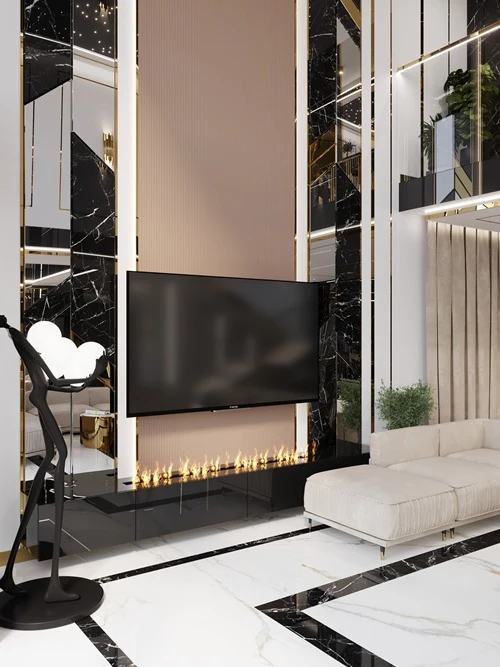Luksusowy salon z dużym telewizorem zawieszonym na ścianie wykończonej czarnym marmurem i złotymi akcentami, pod którym znajduje się nowoczesny kominek liniowy; w rogu jasna, narożna sofa oraz designerska lampa stojąca o nietypowym kształcie, całość do...