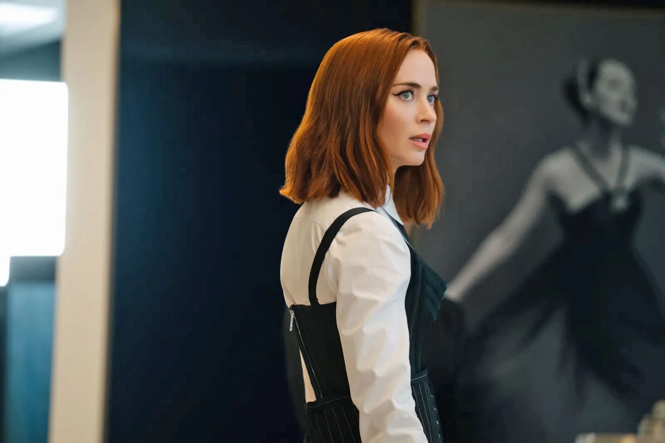 Emily Blunt w scenie z filmu "Diabeł ubiera się u Prady 2" Emily Blunt w "Diabeł ubiera się u Prady 2" w biało-czarnej stylizacji, na tle obrazu baletnicy.