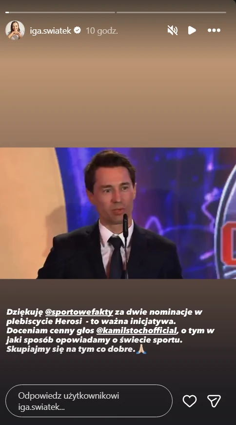 mężczyzna w garniturze stoi za mównicą, wygłaszając przemówienie na tle kolorowej scenografii z elementami niebieskiego i fioletowego światła; na dole widoczny jest tekst podziękowania związany z nominacją w plebiscycie sportowym