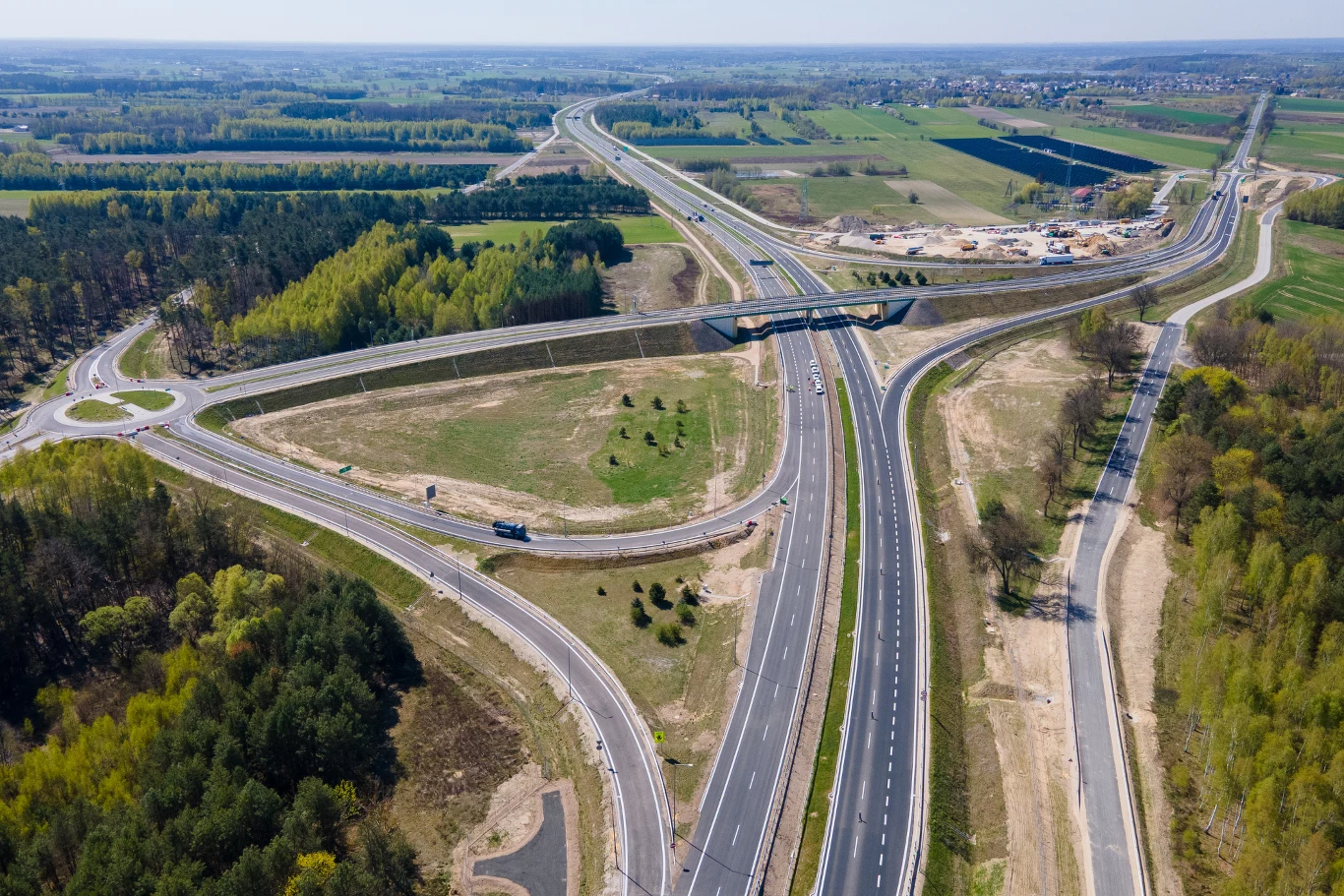 W ramach rozbudowy obwodnicy Kocka powstały również dwa mosty i dwa wiadukty. nowoczesny węzeł komunikacyjny z szerokimi pasami autostrady, rozwidleniem dróg i obiektem mostowym pośrodku, otoczony zielonymi polami oraz fragmentami lasu