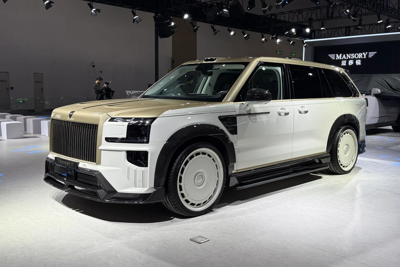 Na stanowisku Mansory ważne miejsce zajmował specjalnie zmodyfikowany Zeekr 9X. luksusowy SUV o dwukolorowym nadwoziu – złotym dachu i masce oraz białym korpusie; masywna atrapa chłodnicy, duże okrągłe felgi oraz charakterystyczne proste linie nadwozia podkreślają prestiżowy charakter pojazdu