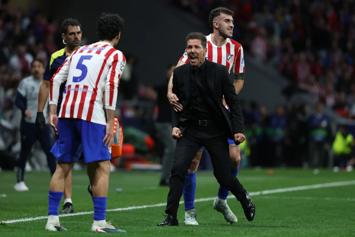 Diego Simeone jak zwykle nie trzymał się kurczowo strefy technicznej trener drużyny w czarnym garniturze wyraża silne emocje przy linii bocznej, obok niego piłkarze w biało-czerwonych koszulkach Atletico Madryt w trakcie meczu