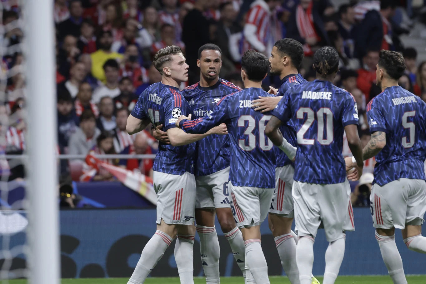 "The Gunners" objęli prowadzenie po bramce Viktora Gyokeresa (pierwszy z lewej) piłkarze ubrane w niebieskie koszulki z krótkimi rękawami, obejmują się i gratulują sobie wzajemnie na boisku podczas meczu piłki nożnej; w tle widoczna publiczność na trybunach