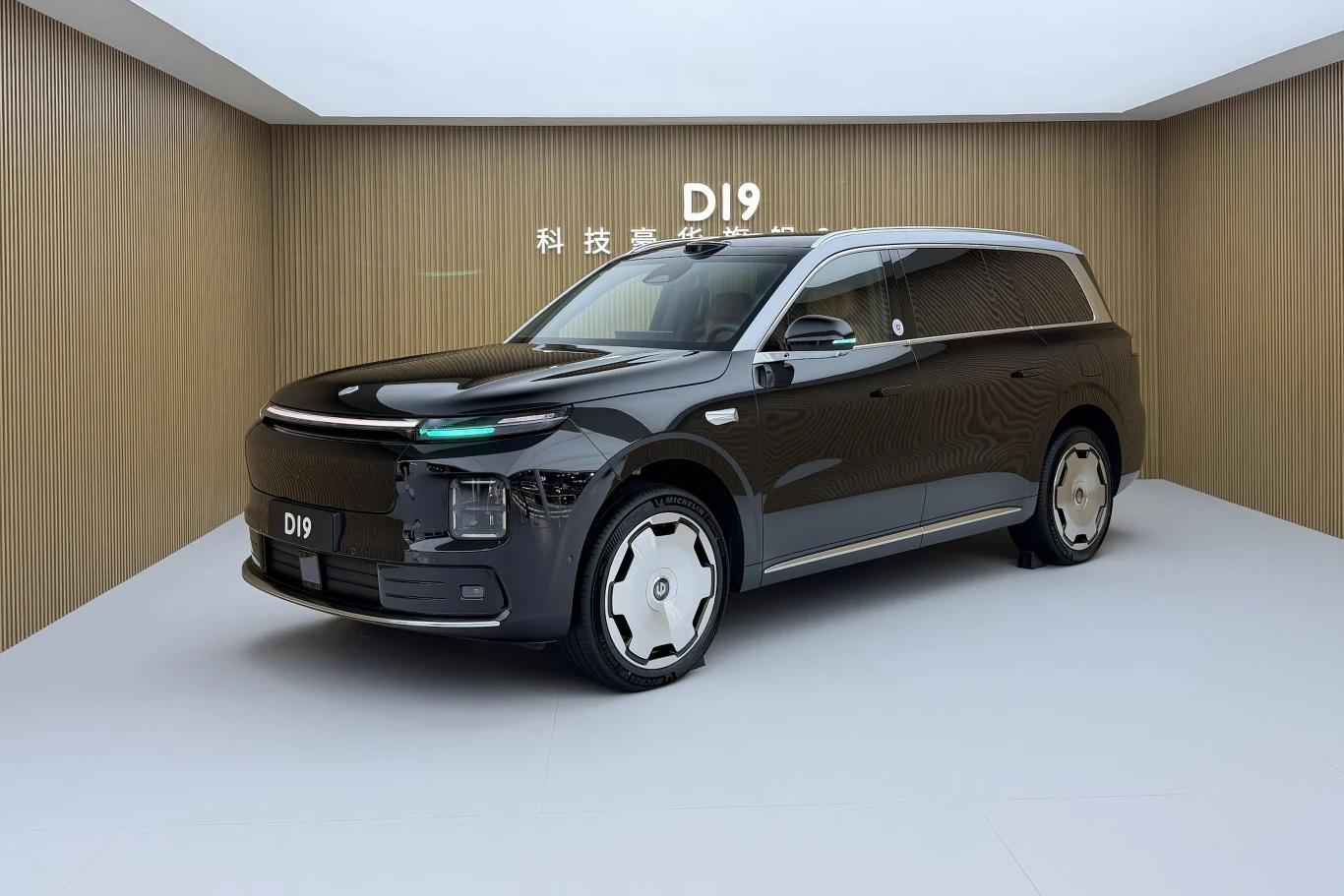 Leapmotor D19 jest większy od BMW X7, ale jednocześnie o wiele tańszy. czarny, nowoczesny samochód typu SUV z jasnym dachem stoi w minimalistycznym pomieszczeniu z drewnianymi ścianami, nad autem widnieje napis „D19”