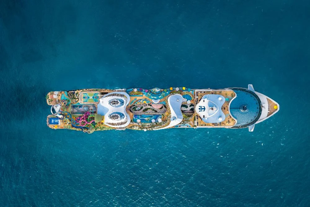 Wycieczkowce klasy Icon biją rekordy. Royal Caribbean zamówiła kolejne jednostki. luksusowy statek wycieczkowy na środku turkusowego morza, widoczny z lotu ptaka, pokład ozdobiony basenami, zjeżdżalniami wodnymi i licznymi atrakcjami rekreacyjnymi