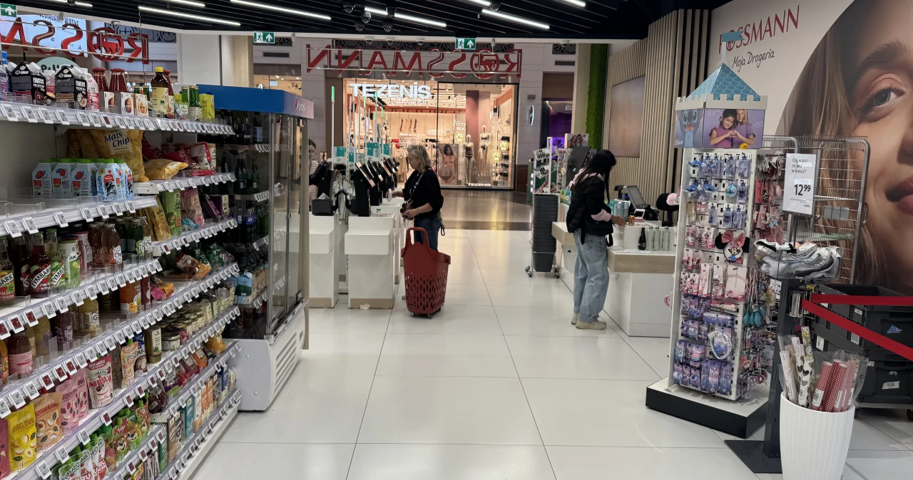 Koszyk za mniej niż 10 zł? Rossmann znów przecenia produkty do 0,99 zł Klientka z czerwonym koszykiem przy kasie samoobsługowej w Rossmann; po bokach regały z kosmetykami i akcesoriami.
