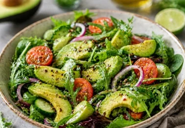 Sałatka z awokado z jajkiem i ogórkiem na białym talerzu