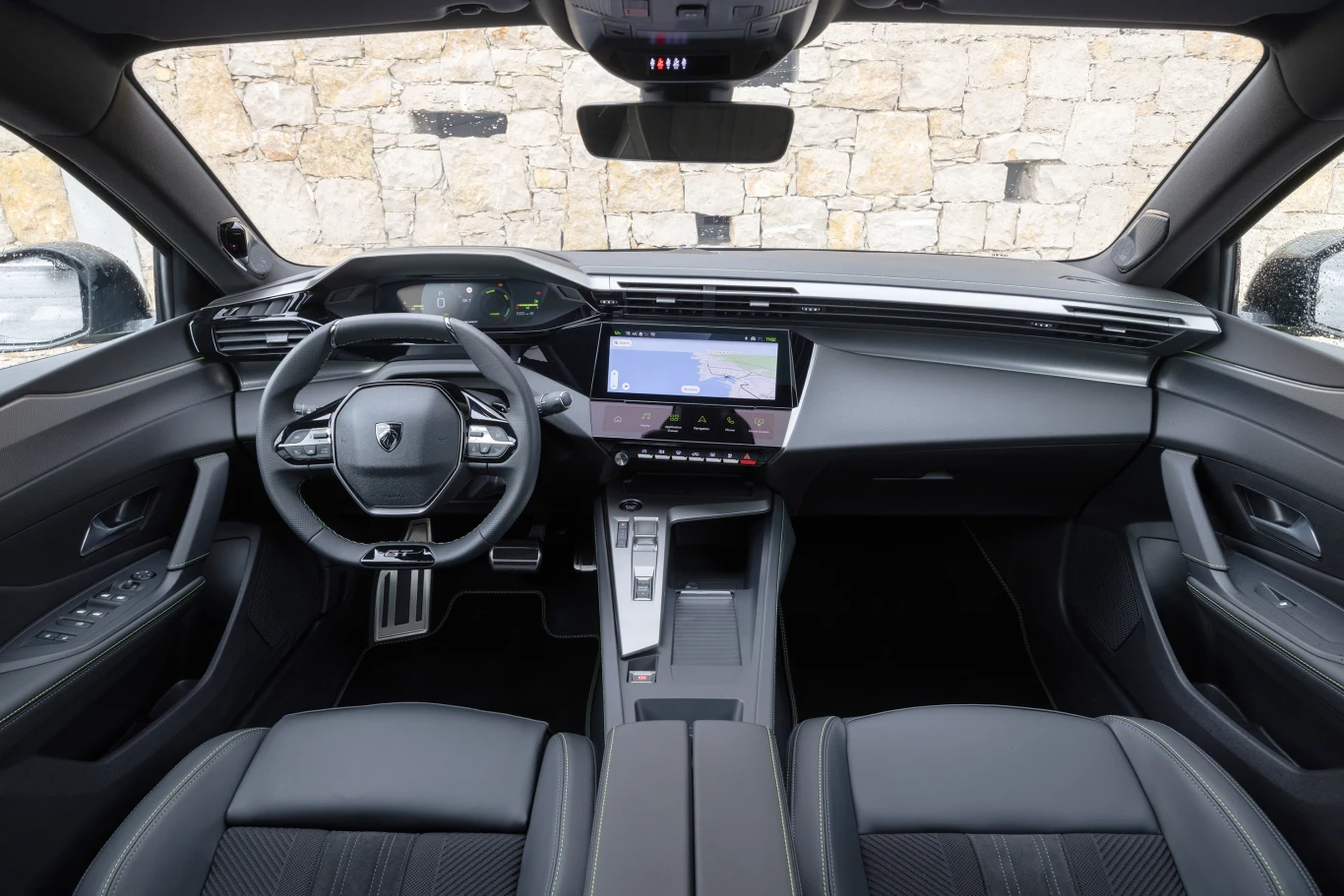W kabinie zastosowano dobrze znaną koncepcję Peugeot i-Cockpit. nowoczesne wnętrze samochodu z cyfrowym kokpitem, dużym centralnym ekranem dotykowym i kompaktową kierownicą, wykończone czarną skórą z eleganckimi przeszyciami, całość utrzymana w minimalistycznym stylu