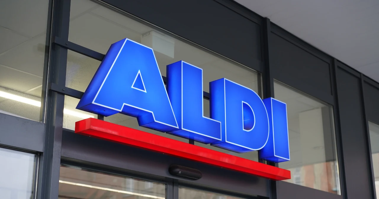 W Aldi pojawił się hit do włosów. Jedno urządzenie robi wszystko i to w zaskakującej cenie Niebieski podświetlany szyld sklepu ALDI z czerwoną linią pod napisem, nad przeszklonym wejściem do budynku