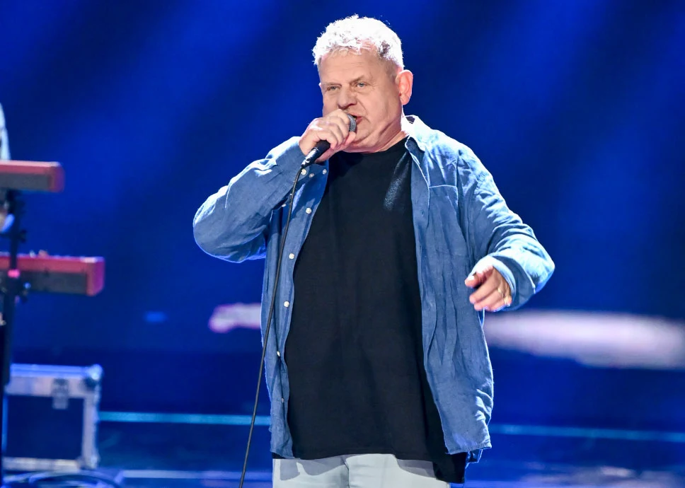 Kazik Staszewski z grupą Kult wraca na scenę Kazik Staszewski podczas koncertu Kult, śpiewa do mikrofonu na scenie w niebieskim świetle, w tle klawiatura.