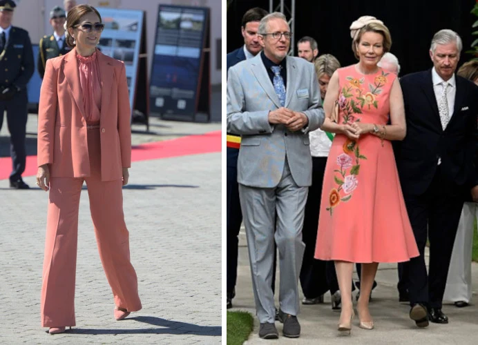 Europejskie królowe w morelowym kolorze Dwie kobiety w eleganckich, łososiowych stylizacjach – po lewej strona szerokie spodnie i marynarka, po prawej sukienka z kwiatowym haftem; towarzyszą im mężczyźni w garniturach, jedna z kobiet ma upięte włosy i opaskę na głowie.