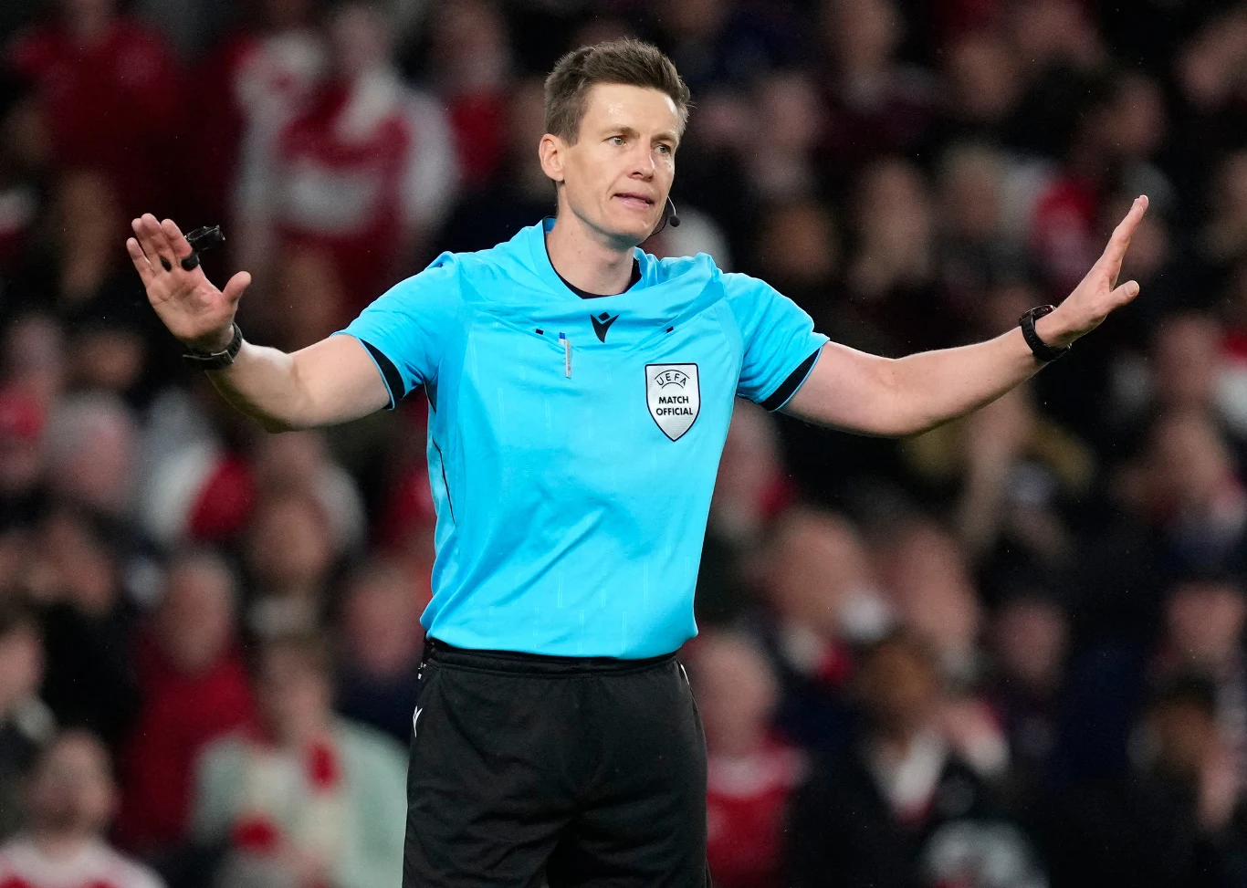 Sędzia Daniel Siebert w meczu Arsenal - Atletico Madryt Sędzia Daniel Siebert w jasnoniebieskim stroju sygnalizuje decyzję podczas meczu Arsenal - Atletico na stadionie.