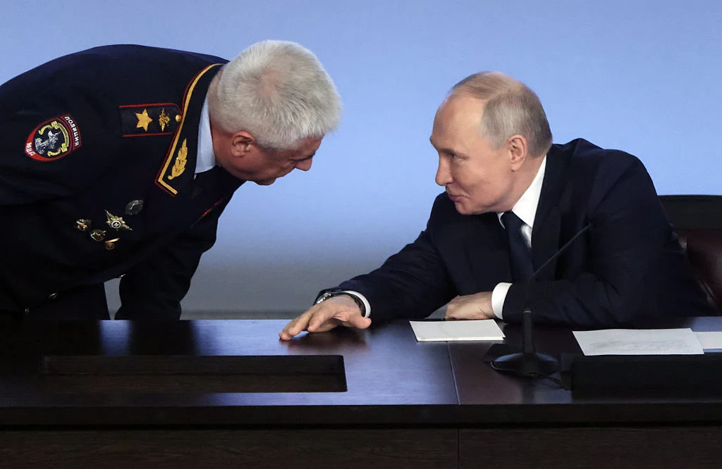 Władimir Putin ma obawiać się także o własne życie Dwóch mężczyzn w garniturze i mundurze rozmawia twarzą w twarz przy stole konferencyjnym, jeden z nich pochyla się w stronę drugiego i wyraźnie się skupiają.