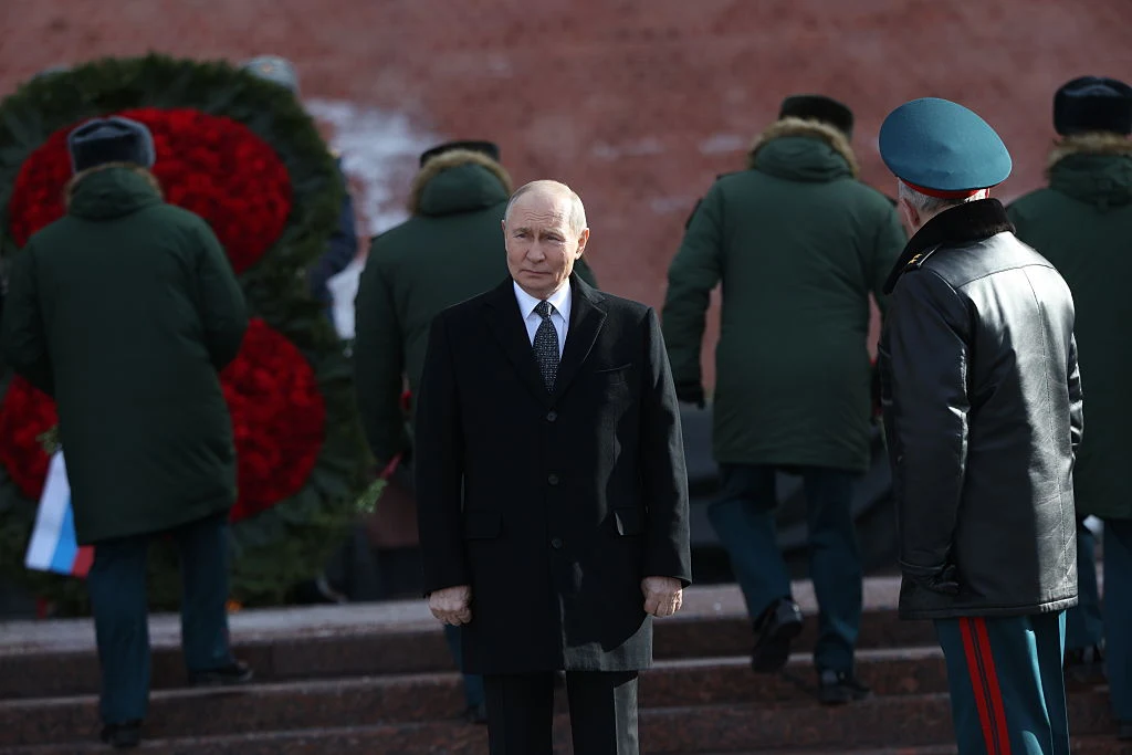 Takiej Parady Zwycięstwa za czasów Władimira Putina jeszcze nie było. Obawy dyktują kolejne zmiany i obostrzenia Władimir Putin w ciemnym płaszczu stoi obok żołnierza, w tle żołnierze składają wieńce z czerwonych kwiatów przy ceglanej ścianie.