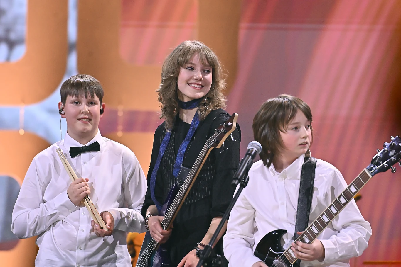 Grupa ADHD została zaproszona do finału Eliminacji do Pol'and'Rock Festivalu Trójka nastolatków z zespołu ADHD na scenie przed mikrofonem, ubrani w białe koszule, z instrumentami muzycznymi.