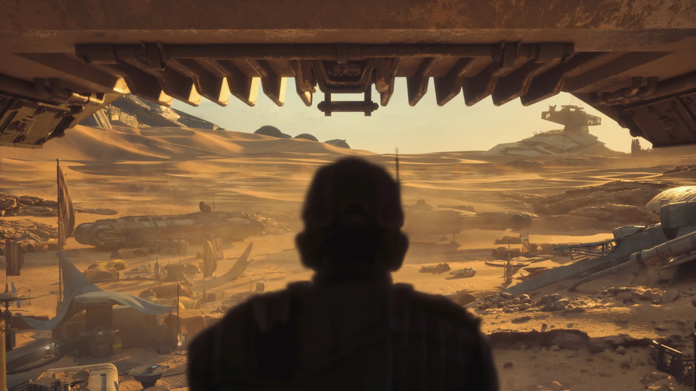 Star Wars: Galactic Racer Sylwetka osoby stojącej w cieniu u wejścia do dużego pojazdu, patrzącej na pustynię z wrakami statków i maszyn.