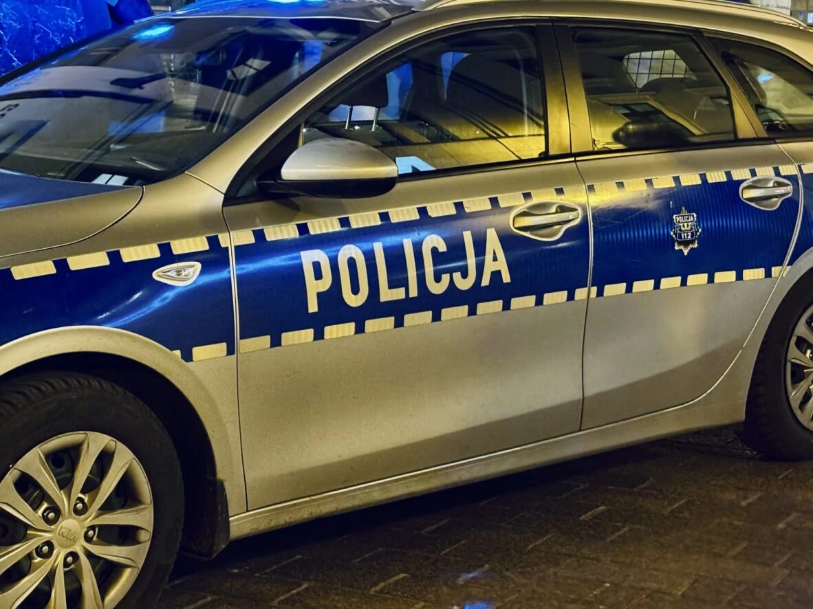 Tragedia w Poznaniu. 40-latek zginął po interwencji policji. Zdj. ilustracyjne Radiowóz policyjny z włączonymi światłami sygnalizacyjnymi na ulicy w Poznaniu po zmroku.
