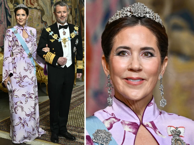 Królowa Maria i król Fryderyk X na przyjęciu urodzinowym króla Szwecji Elegancka kobieta w długiej, jasnofioletowej sukni w kwiatowe wzory i koronie na głowie oraz mężczyzna w czarnym fraku z licznymi orderami i ozdobami, stojący obok niej na wzorzystym dywanie w pałacowym wnętrzu.