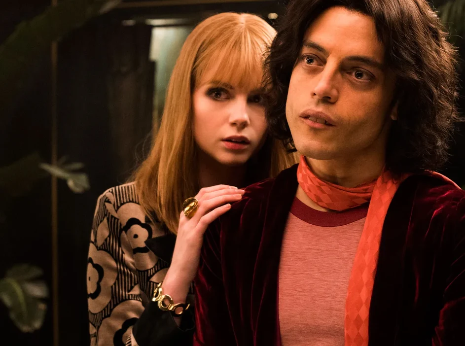 "Bohemian Rhapsody" Dwoje młodych ludzi w stylizacjach retro, kobieta z rudymi włosami z ręką opartą na ramieniu mężczyzny z ciemnymi włosami
