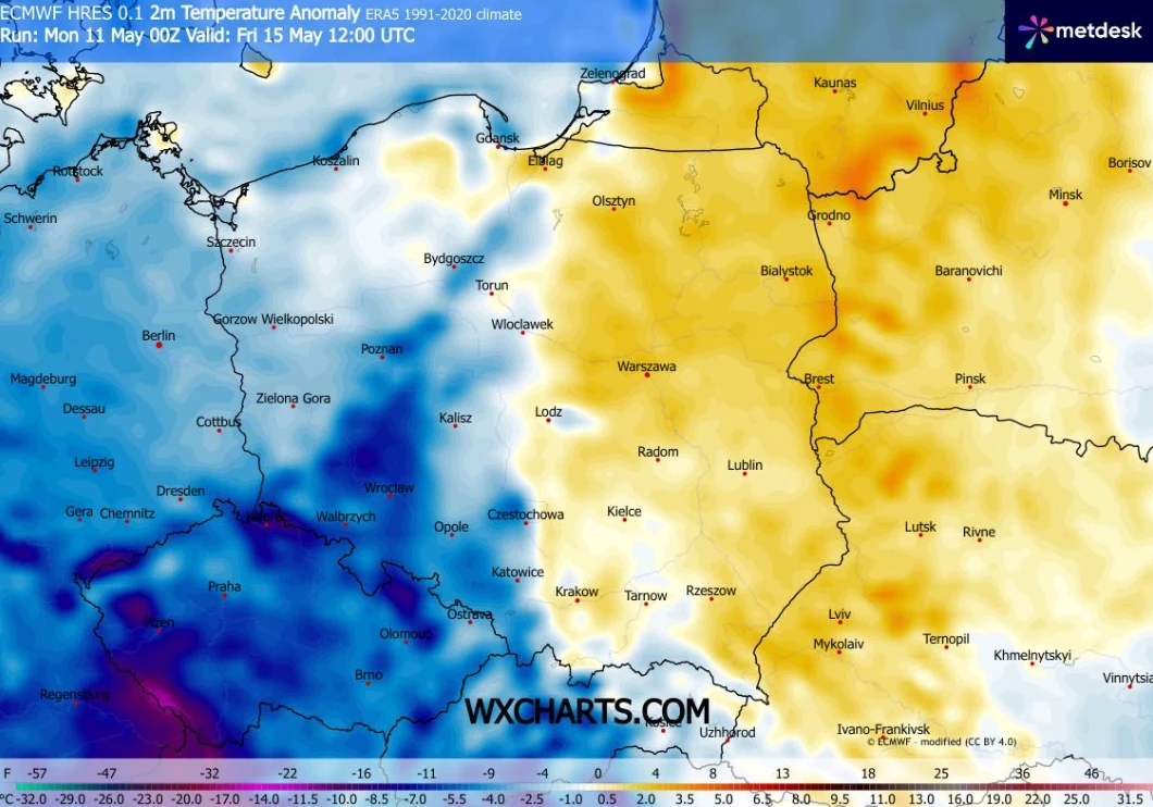 Mapa Polski z wyraźnym podziałem na zachodnią część pokrytą niebieskimi odcieniami, oznaczającymi niższe anomalie temperatury, oraz wschodnią część w odcieniach żółci i pomarańczu, wskazujących na wyższe od normy wartości temperatury, z granicą przebie...