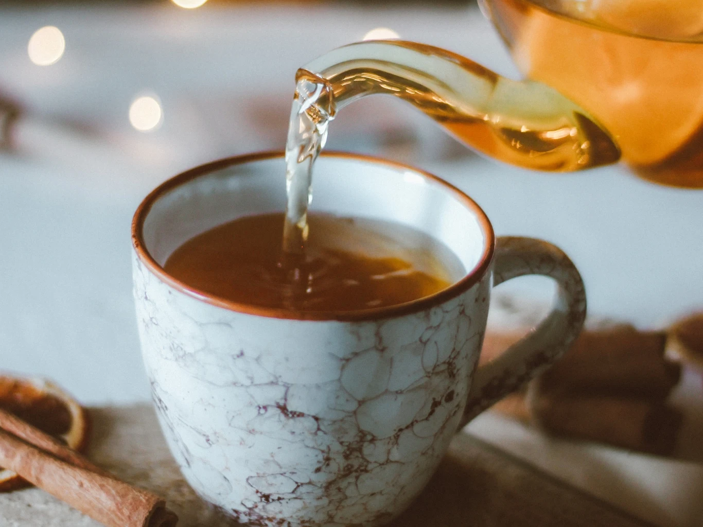 Dodaj szczyptę tej przyprawy do herbaty. Podkręci metabolizm i przyspieszy odchudzanie. Ceramiczny kubek z herbatą zalewaną z dzbanka, obok leży laska cynamonu.