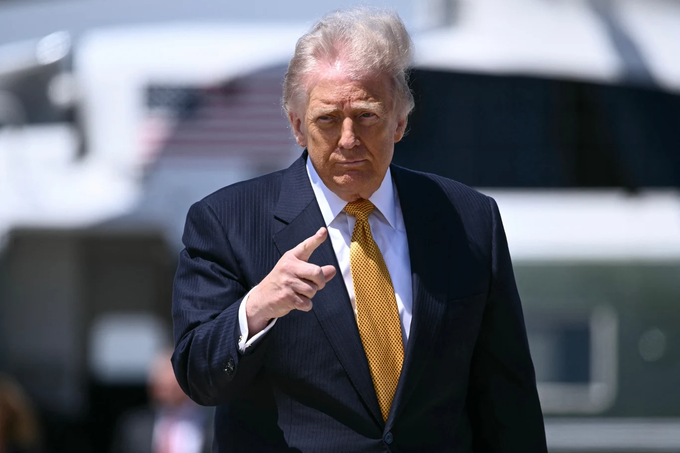 Donald Trump przekazał, o czym będzie rozmawiał z Xi Jinpingiem Donald Trump w garniturze i żółtym krawacie wskazuje palcem przed siebie; w tle pojazd z flagą USA.