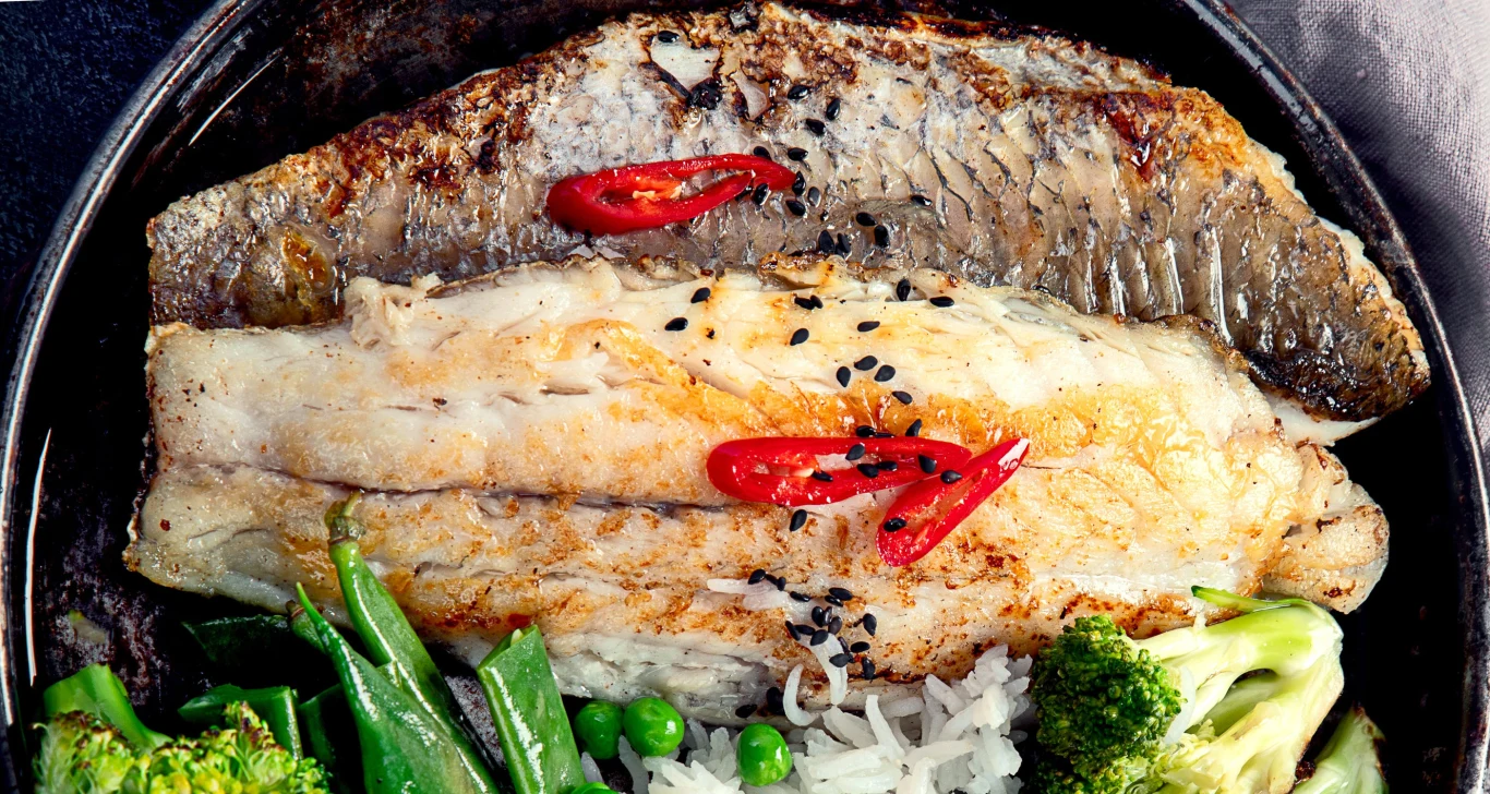 Królewska ryba zbyt rzadko gości w naszym menu. Grillowany filet dorady z czarnym sezamem i papryczką chili, podany z ryżem i zielonymi warzywami.