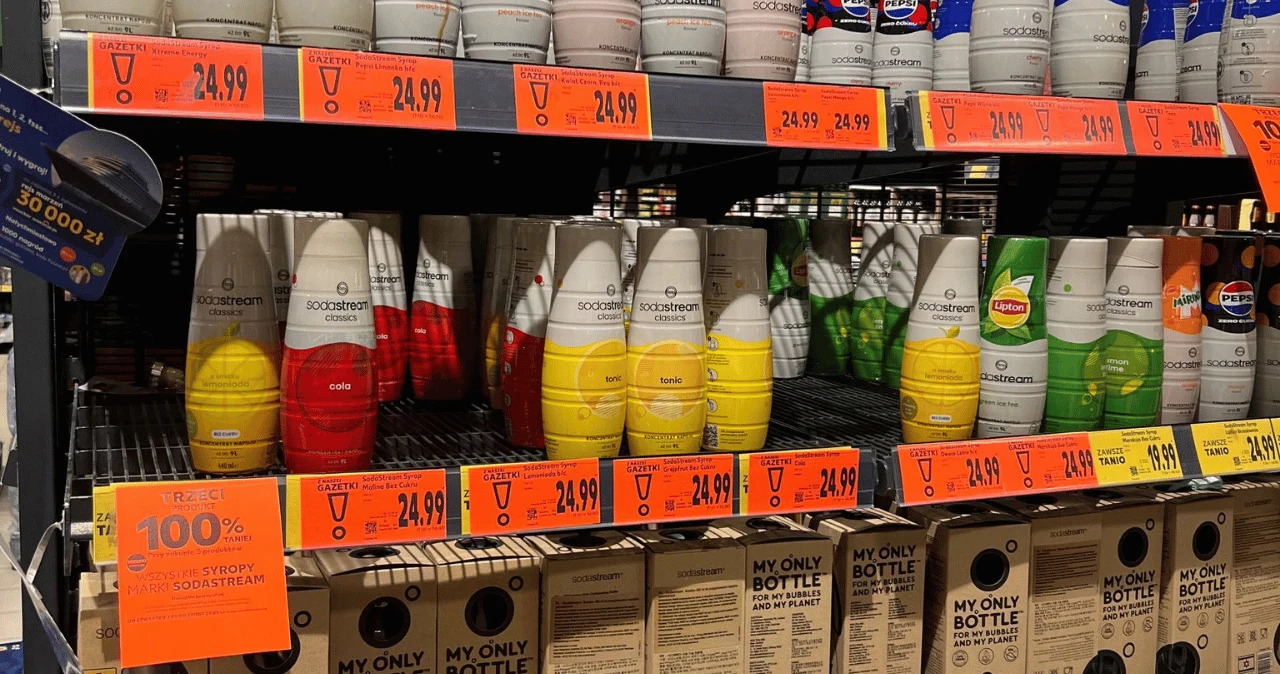 Kaufland przecenia syropy SodaStream. Trzeci produkt kosztuje 0 zł do 20 maja Szereg kolorowych syropów SodaStream na półce w Kauflandzie, poniżej kartony 'My Only Bottle' i ceny 24,99.