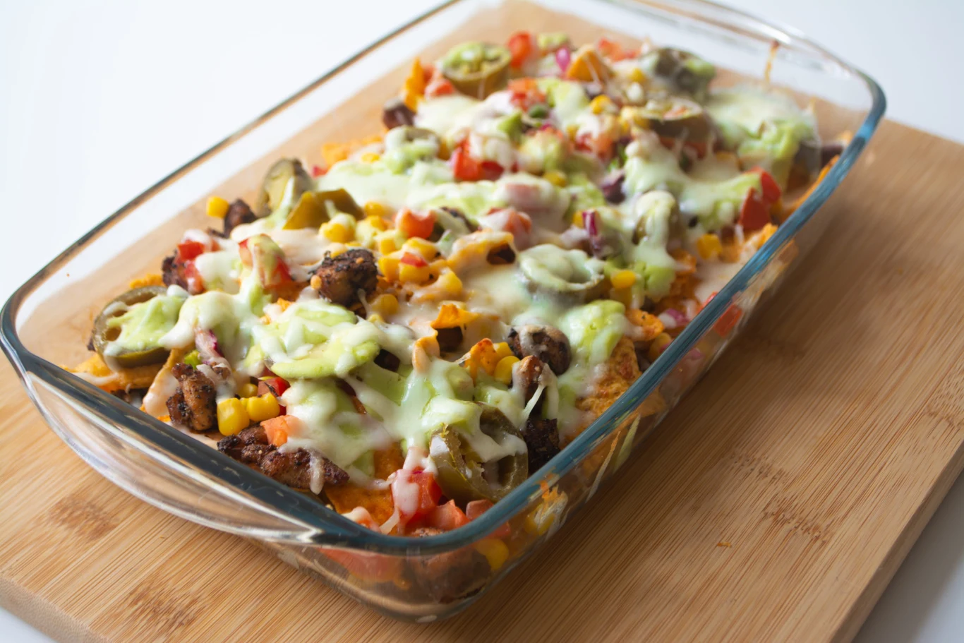Prosta zapiekanka w meksykańskim stylu to sycący i smaczny posiłek Zapiekanka Mexico z warzywami, roztopionym serem i papryczkami jalapeño w naczyniu żaroodpornym