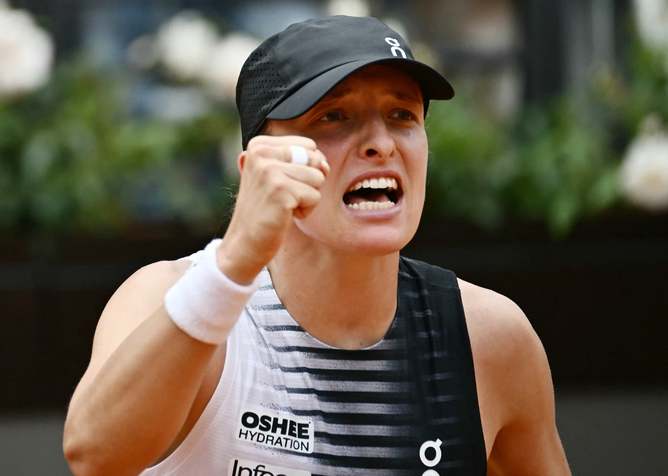Iga Świątek po meczu z Jessicą Pegulą w Rzymie Tenisistka w sportowej koszulce i czapce z daszkiem zaciska pięść w geście triumfu, wyrażając silne emocje podczas meczu.