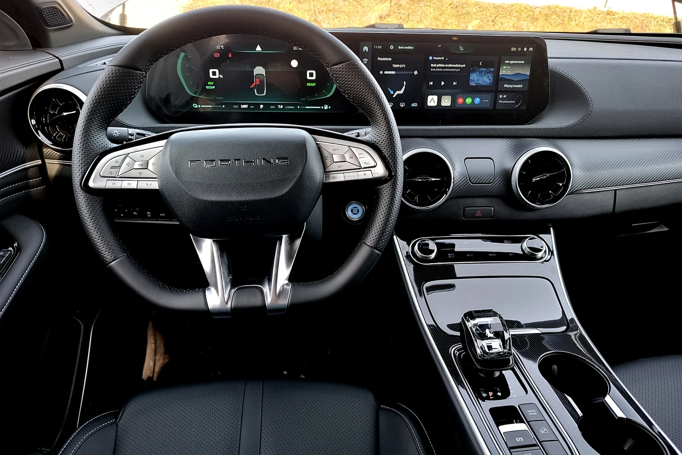 Nowoczesna deska rozdzielcza Porsche z cyfrowym zestawem wskaźników, dużym ekranem multimedialnym oraz elegancką kierownicą wykończoną skórą.