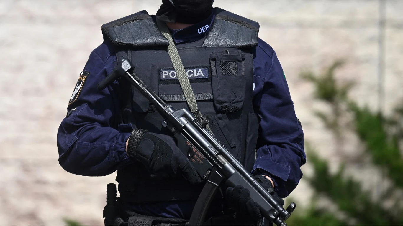 Zdj. ilustracyjne. Portugalskie służby wszczęły obławę za uciekinierem z sądu Portugalski policjant w kamizelce kuloodpornej.