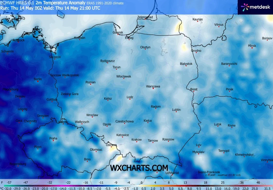 Mapa Polski z zaznaczonymi anomaliami temperatury na tle niebieskich i granatowych barw wskazujących na obszary znacznie niższych temperatur, szczególnie na zachodzie i południu kraju, z nazwami miast rozmieszczonymi na całym obszarze mapy.
