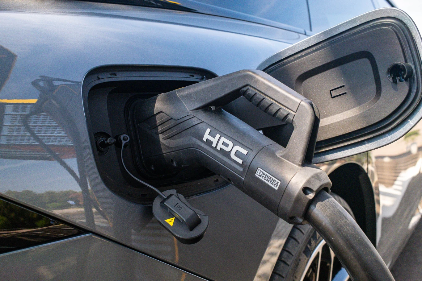 Wtyczka ładowarki HPC podłączona do portu ładowania samochodu elektrycznego.