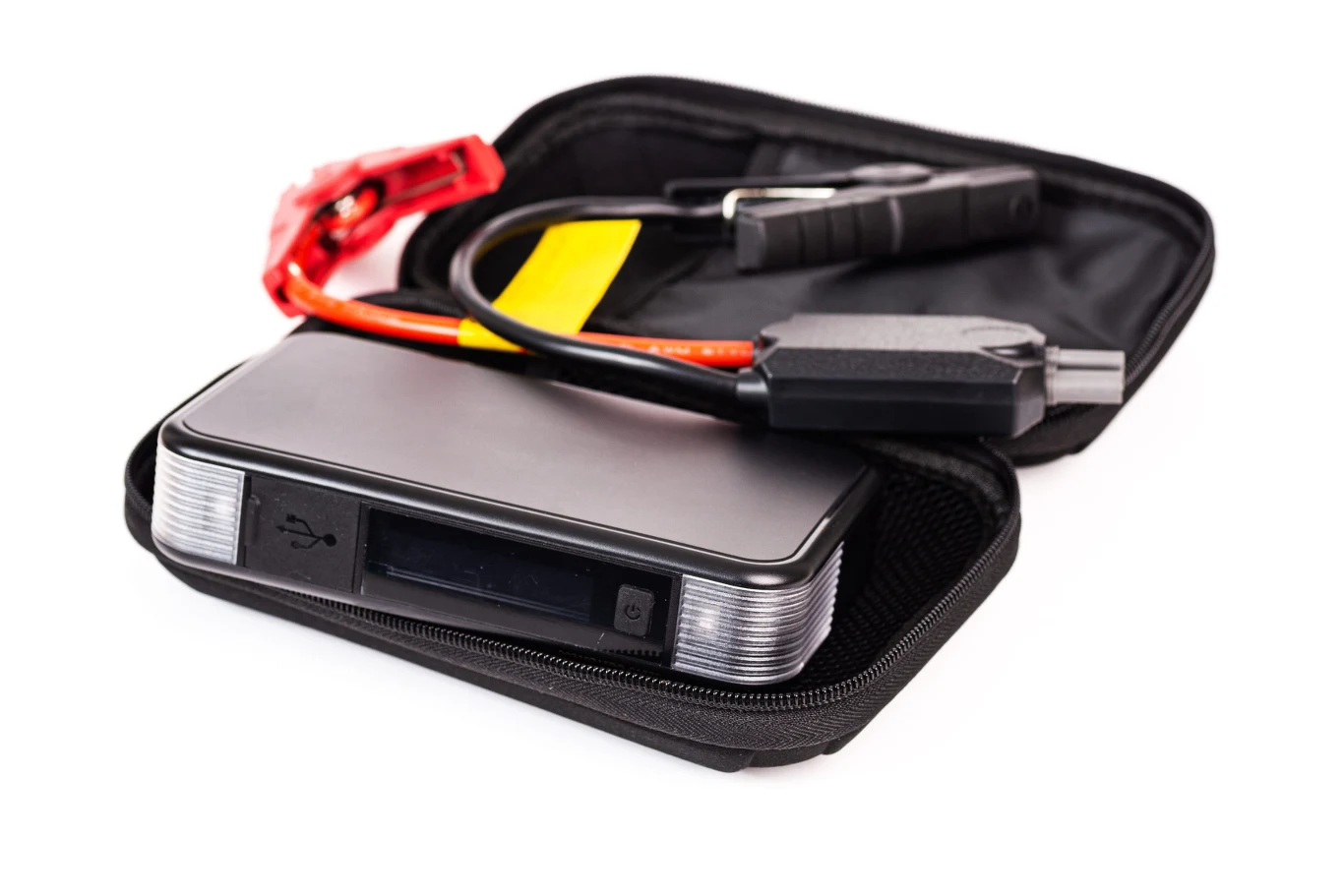 Powerbank z funkcją rozruchu samochodowego umieszczony w etui, razem z przewodami umożliwiającymi podłączenie do akumulatora pojazdu.