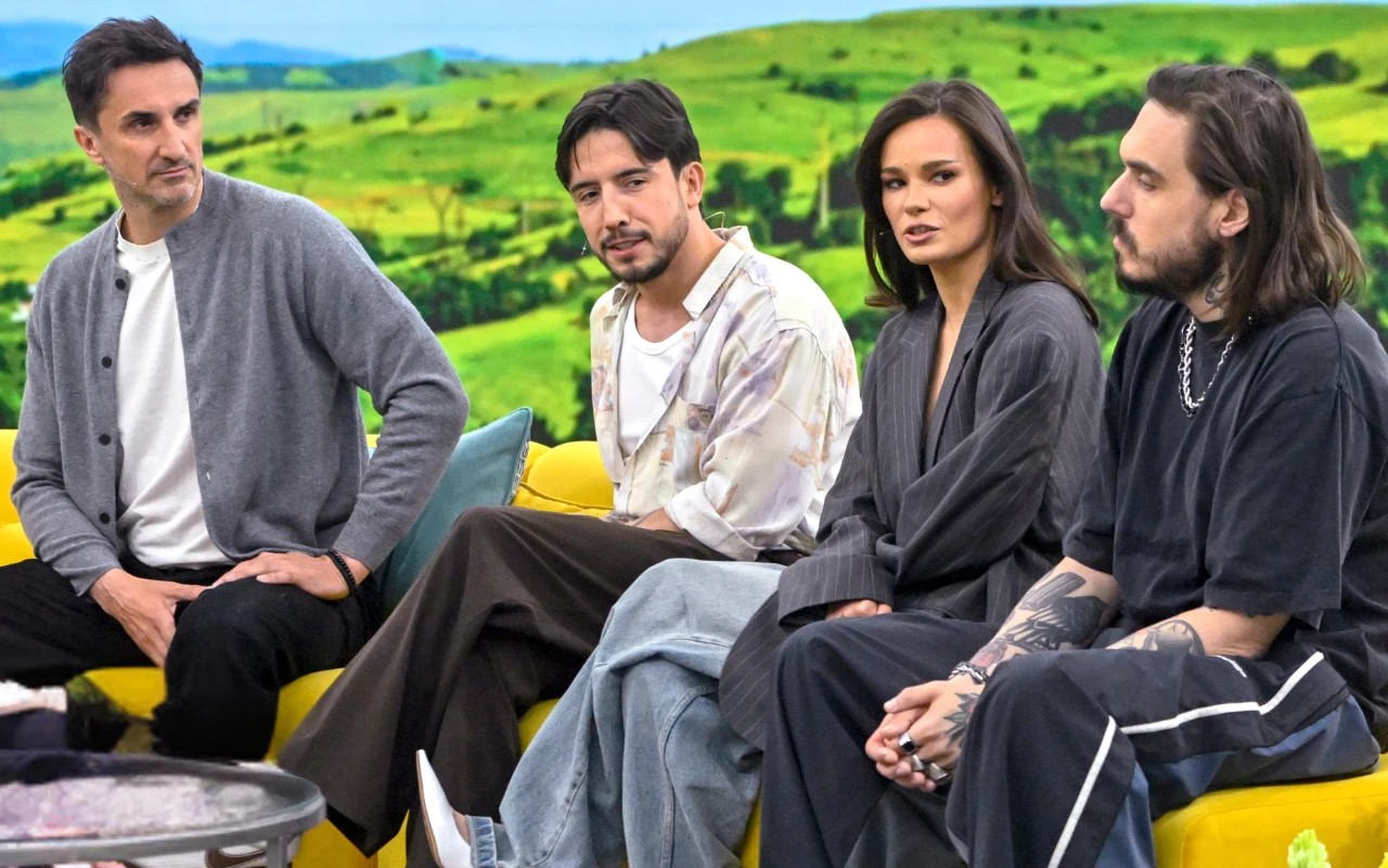 Jurorzy "MBTM" w "halo tu polsat" Czworo osób siedzących na żółtej kanapie, pogrążonych w rozmowie, w tle rozległy zielony krajobraz za dużym oknem.
