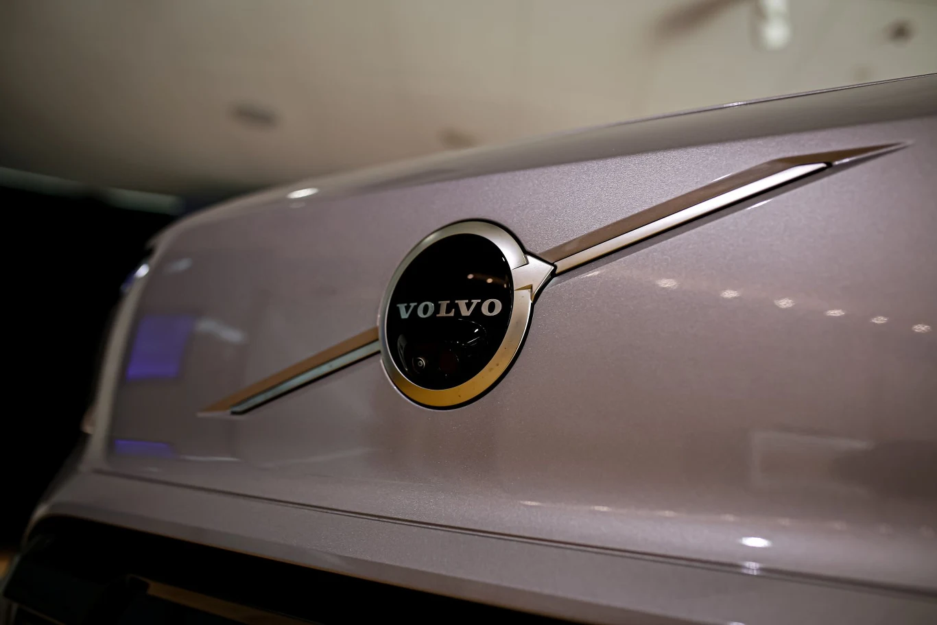 Logo marki Volvo umieszczone centralnie na masce samochodu z charakterystycznym chromowanym wykończeniem.