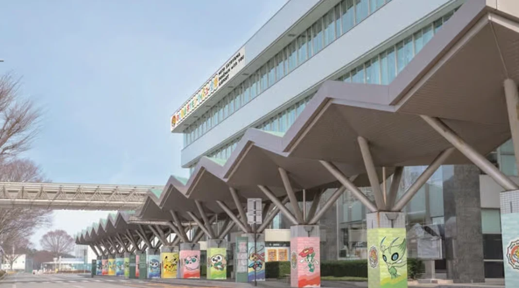 Budynek o nowoczesnej, przeszklonej fasadzie z charakterystycznym falistym daszkiem podtrzymywanym przez rzędy skośnych kolumn, ozdobionych wielobarwnymi plakatami z postaciami z kreskówek.