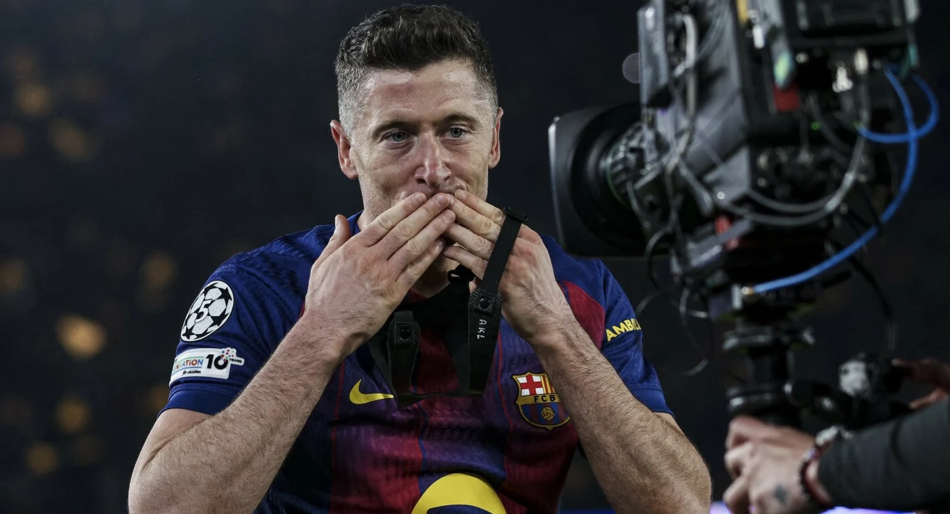 Piłkarz w koszulce FC Barcelony wykonuje gest pocałunku w kierunku kamery podczas meczu piłkarskiego.
