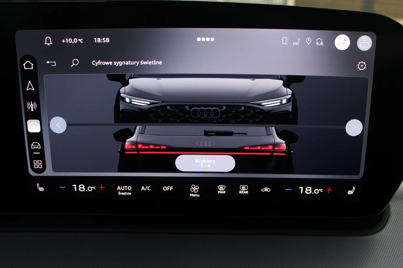 Ekran systemu multimedialnego Audi prezentujący cyfrowe sygnatury świetlne, z widocznym podglądem przednich i tylnych świateł pojazdu oraz ustawieniami klimatyzacji na panelu dolnym.