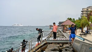 Turysta wraz z instruktorami wraca po sesji nurkowania w pobliżu plaży Rasfannu w Malé, 15 maja 2026 r.