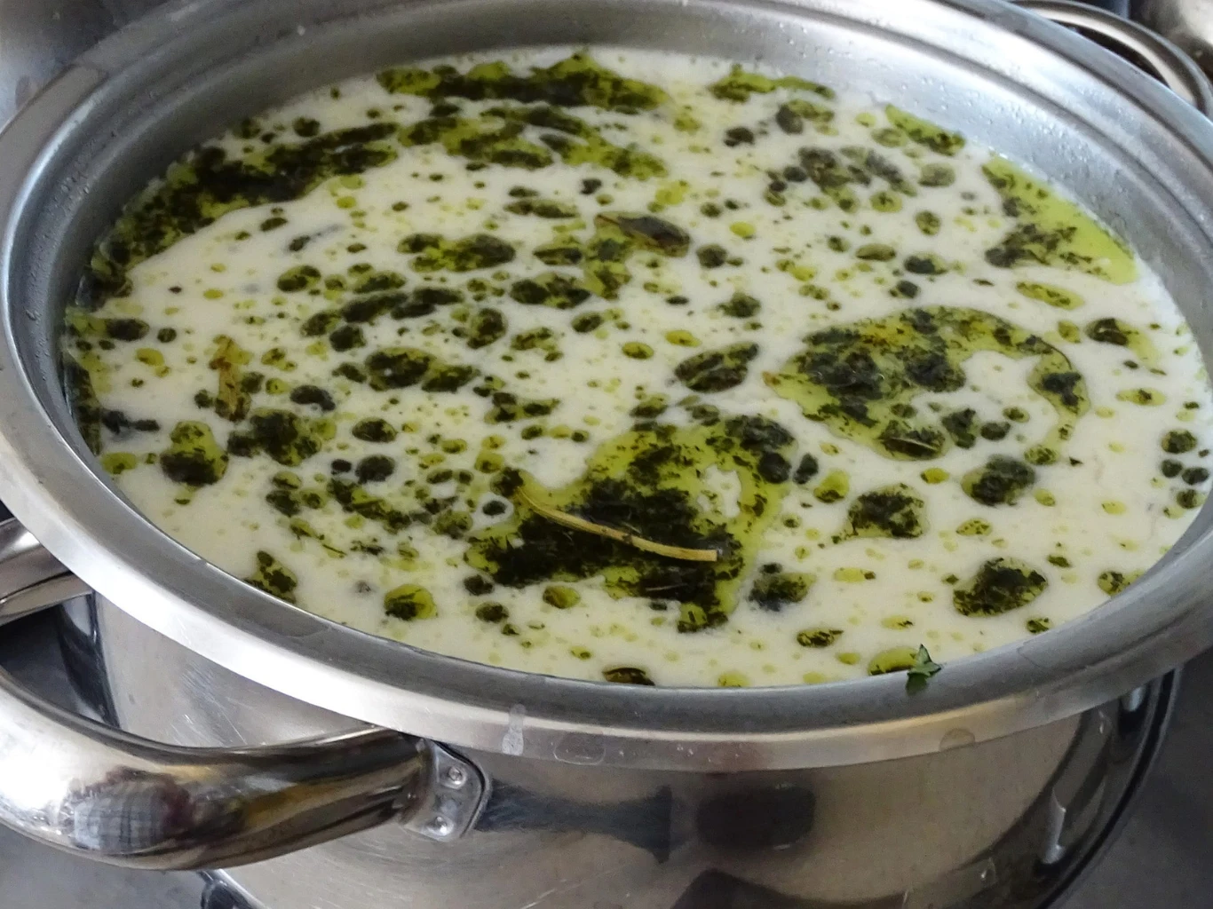 Zupa kwas z kujaw jest bogatsza w smaku od kapuśniaka Garnek z jasną, kremową zupą kwas z widocznymi zielonymi przyprawami i cienką warstwą masła na wierzchu.