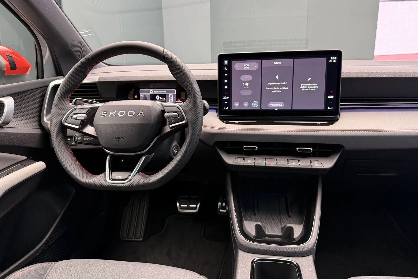 Nowoczesna deska rozdzielcza samochodu Skoda z cyfrowymi wyświetlaczami, wielofunkcyjną kierownicą oraz dużym ekranem dotykowym systemu multimedialnego po prawej stronie.