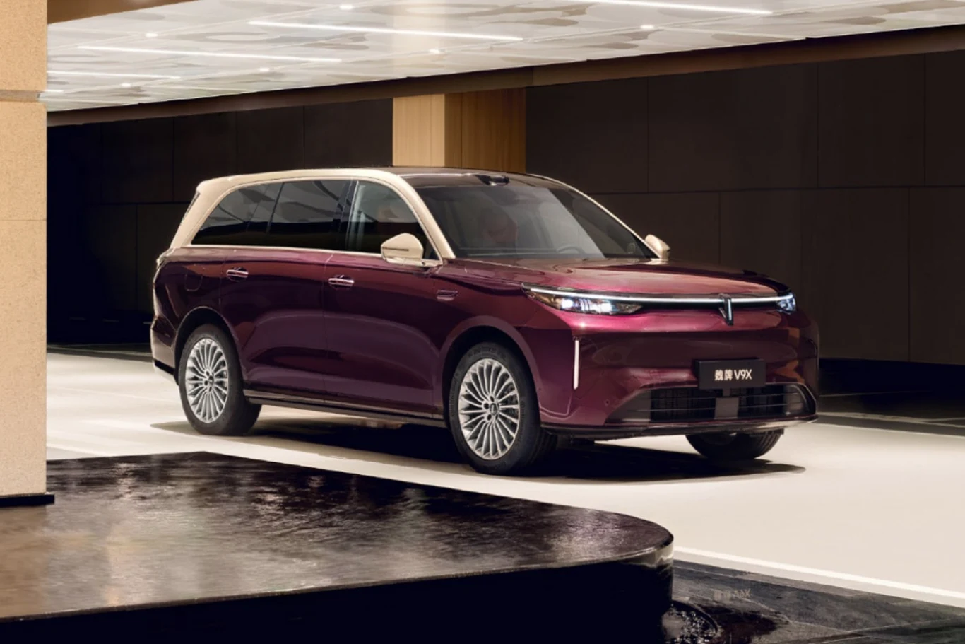 Ten elektryczny SUV z Chin dysponuje łącznym zasięgiem wynoszącym 1700 km. Fioletowy hybrydowy SUV typu plug-in marki Wey zaparkowany w przestronnym, jasnym wnętrzu budynku.