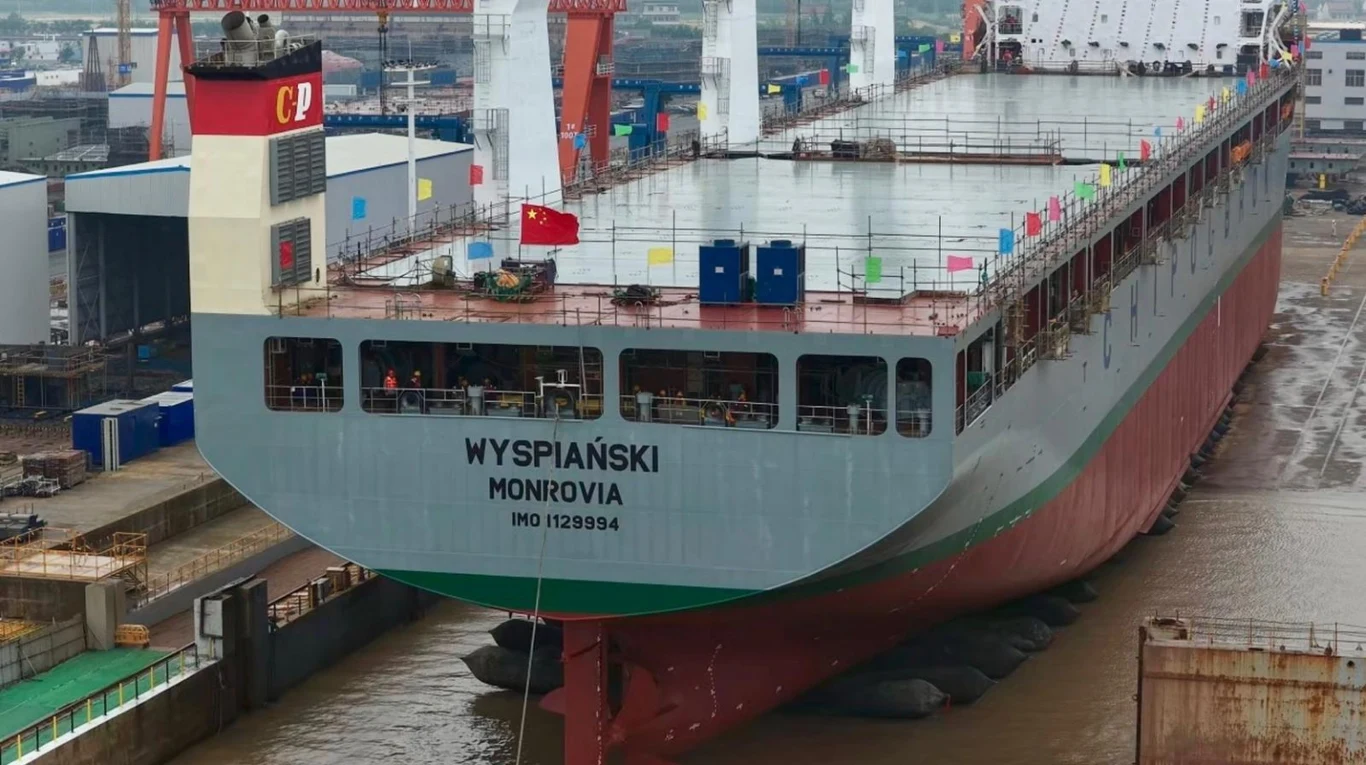 Duży kontenerowiec o nazwie WYSPIAŃSKI zakotwiczony w stoczni, z widocznymi oznaczeniami portu macierzystego Monrovia oraz charakterystycznym czerwono-biało-zielonym kadłubem.
