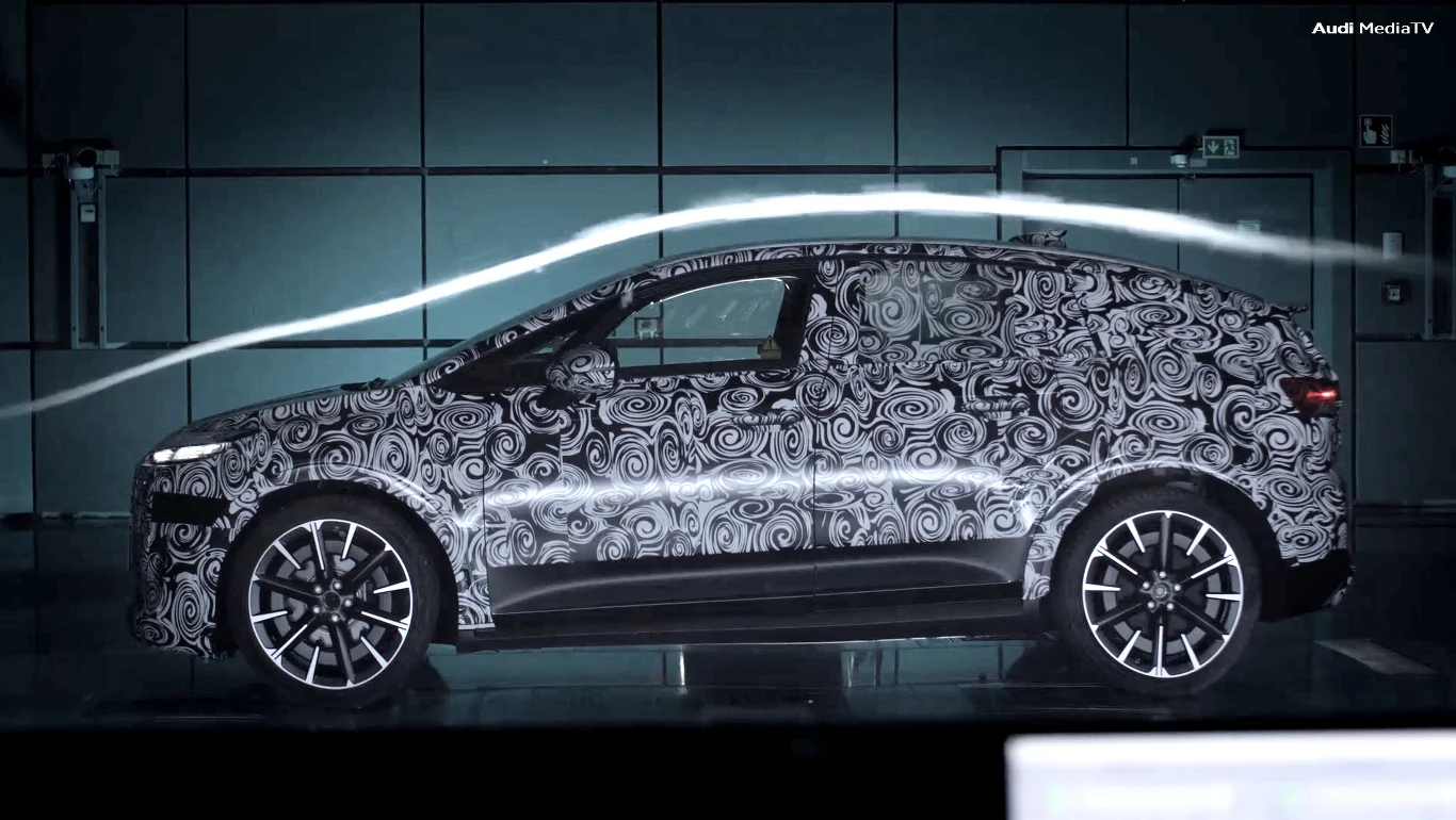 Kamuflowany samochód typu SUV z nowoczesnym wzorem maskującym podczas testów aerodynamicznych w tunelu powietrznym.