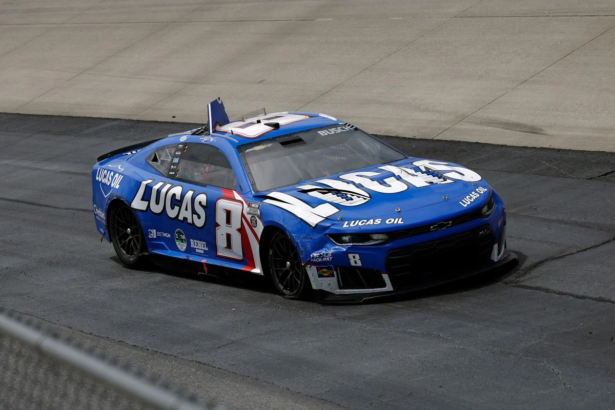 Niebieski samochód wyścigowy z numerem 8 i dużym logo Lucas Oil, jadący po asfaltowej trasie toru wyścigowego.