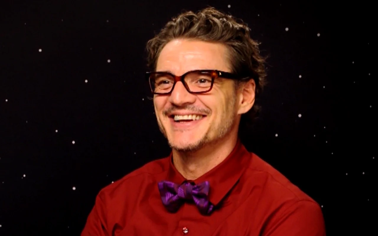 Pedro Pascal w wywiadzie Maksa Behra Uśmiechnięty Pedro Pascal w bordowej koszuli i fioletowej muszce na tle nieba z gwiazdami