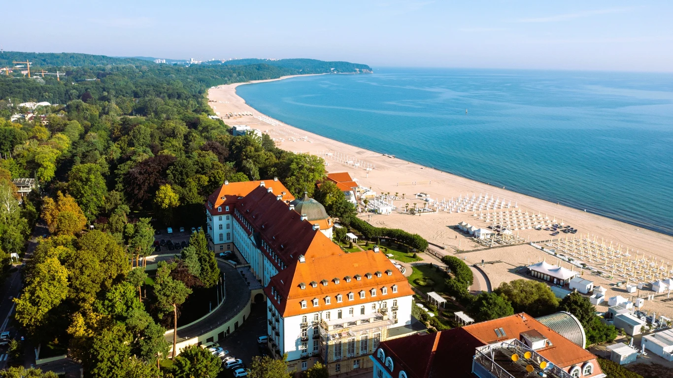 Wakacje nad Bałtykiem mogą być inne niż zwykle. Koniec z narzekaniem na pogodę i ceny Hotel z czerwonym dachem przy szerokiej, piaszczystej plaży Bałtyku, otoczony zielenią i widokiem na morze.