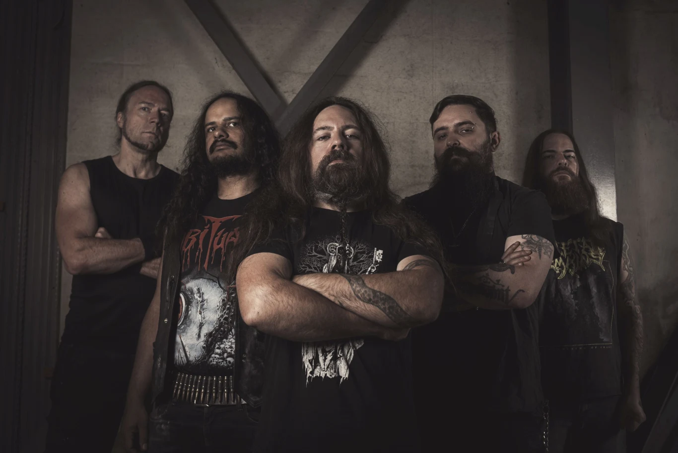 Fleshcrawl przed premierą Pięciu członków zespołu Fleshcrawl w czarnych koszulkach metalowych na tle industrialnej ściany.